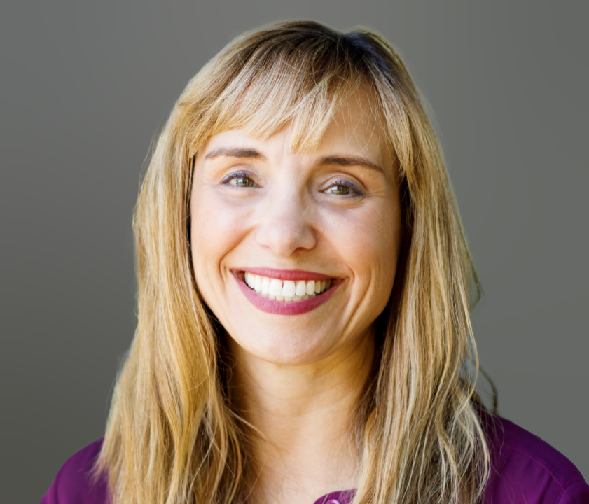 a woman with long blonde hair smiling at the camera