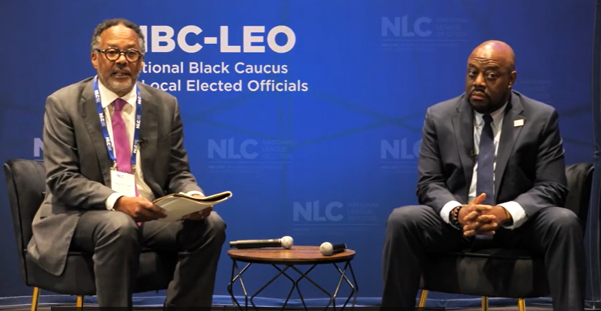 Two men, Ralph Clark and Savannah Mayor Van R. Johnson II, in chairs on a stage speaking at the NBC-LEO in 2026