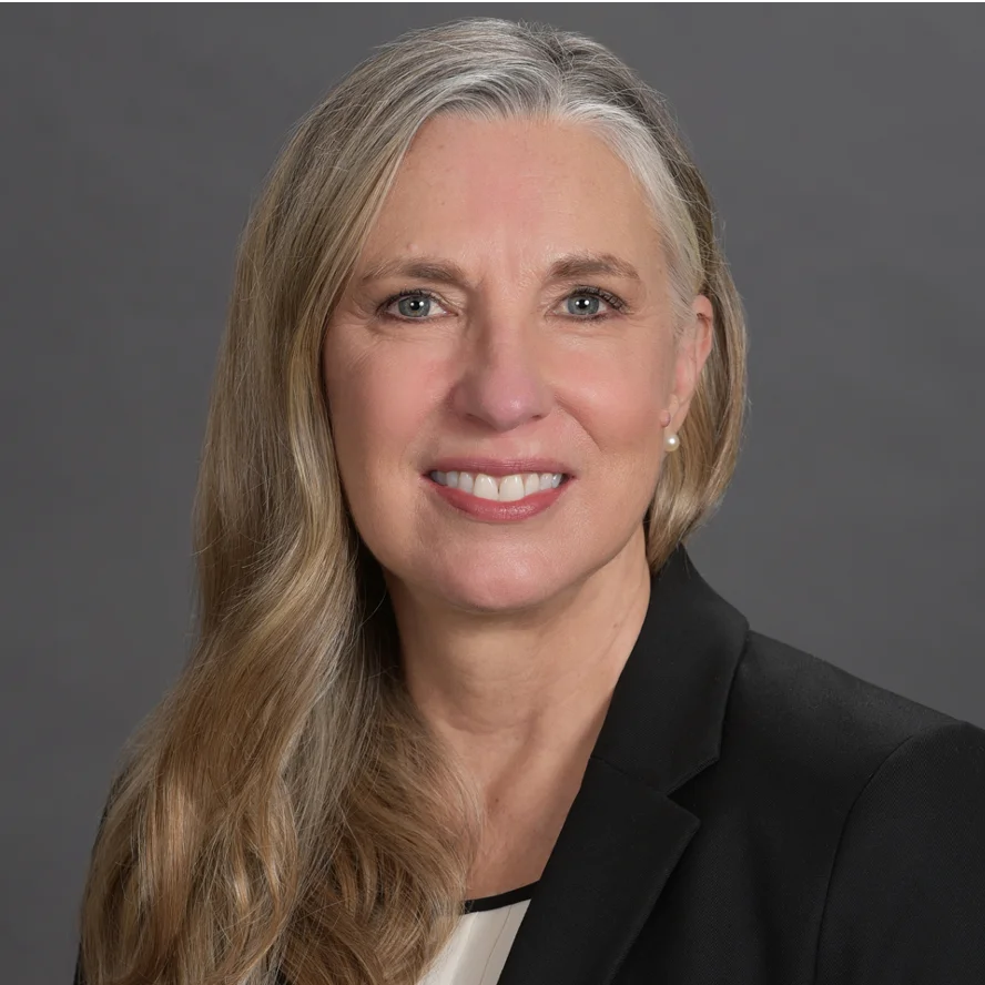 a woman wearing a black jacket and white shirt