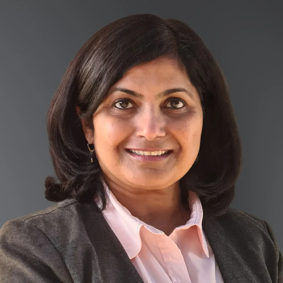 a woman in a business suit smiling at the camera