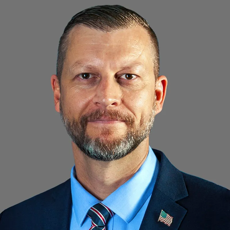 a man with a beard wearing a suit and tie