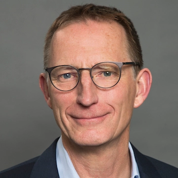 a man in a suit and glasses smiling