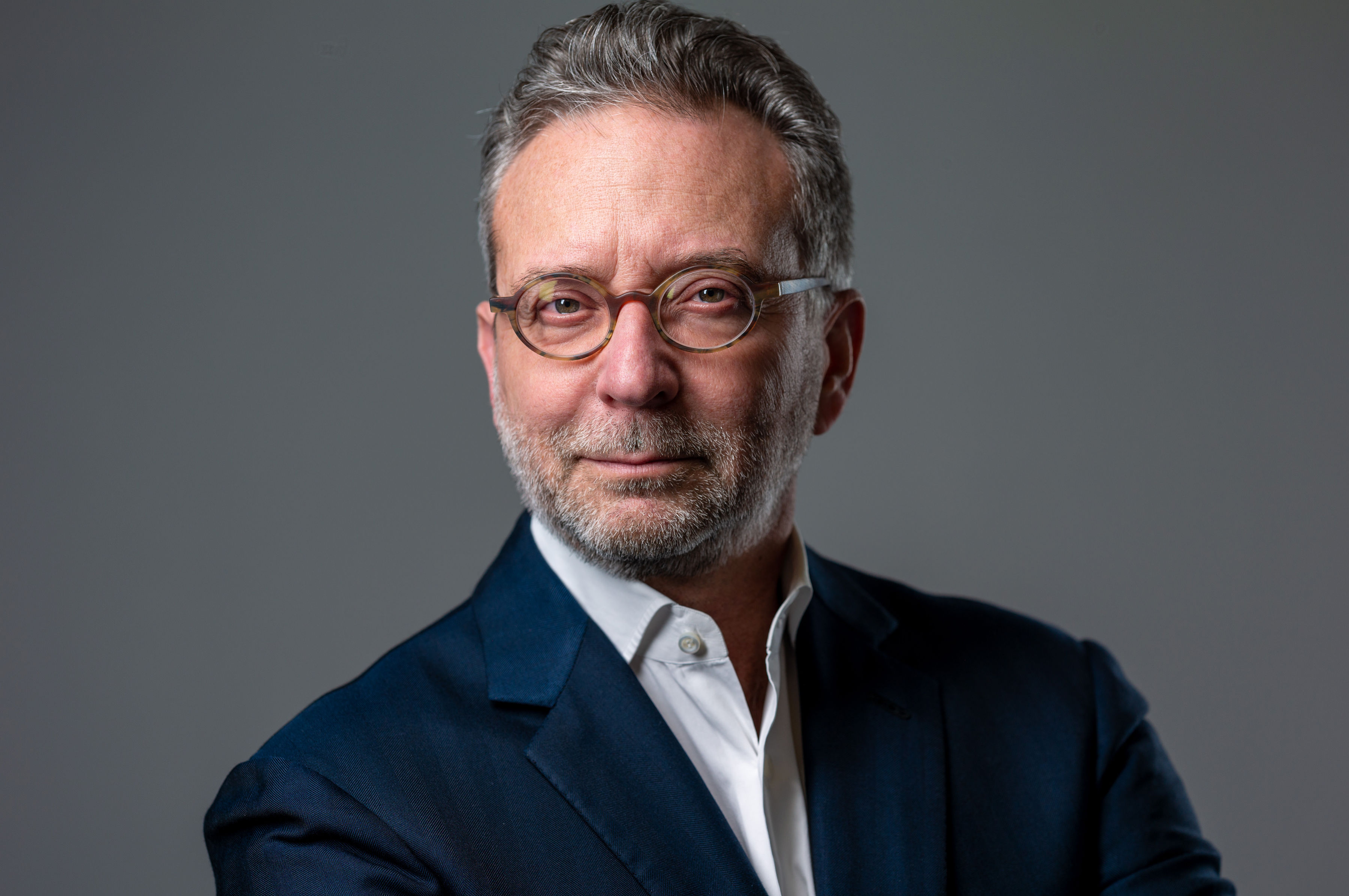 a man in a suit and glasses posing for a picture