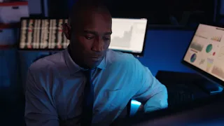 a man sitting in front of a computer monitor