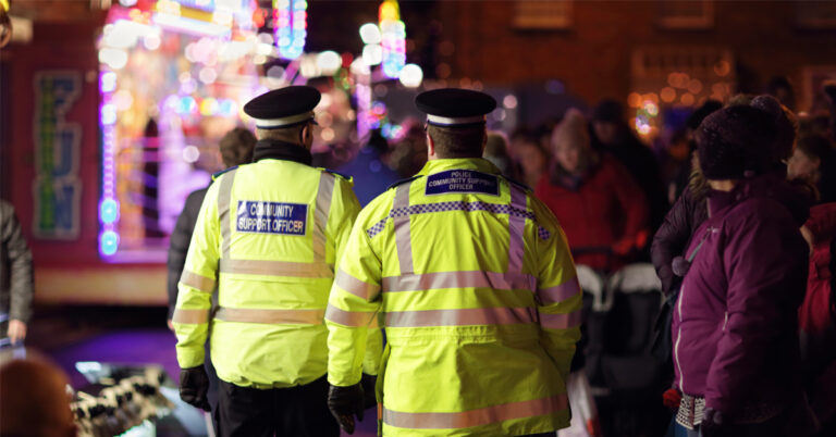 two police officers standing in front of a crowd of people