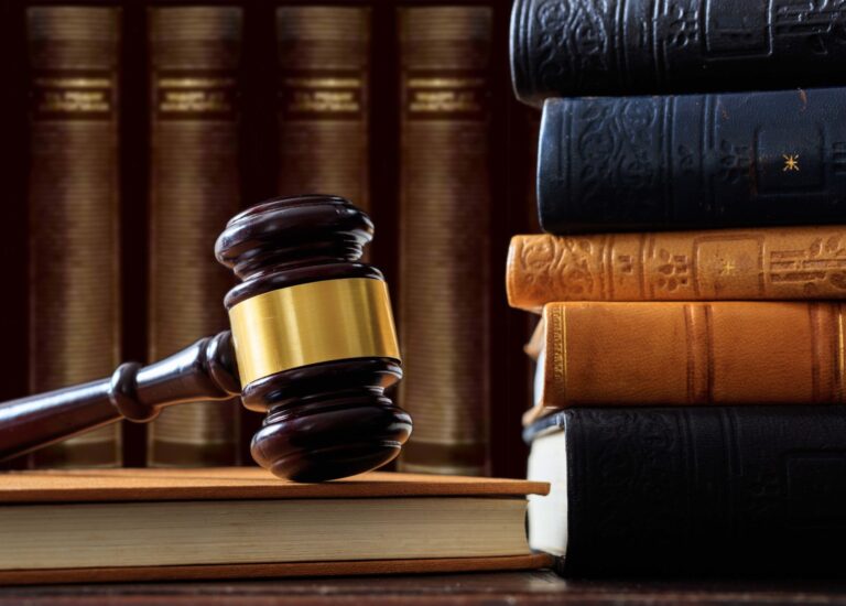 a judge's gaven sitting on top of a wooden table next to a stack of law books