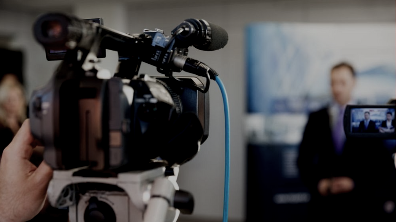 a person holding a camera in front of a television screen