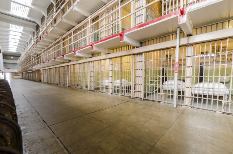 a jail cell with several beds and bars