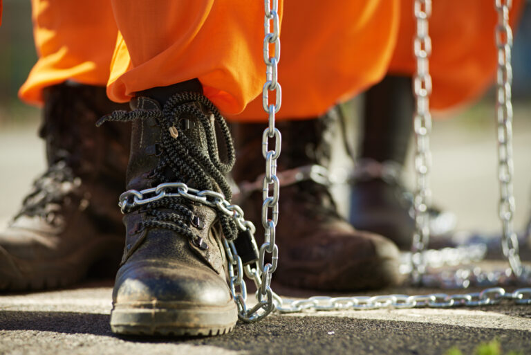 a close up of a person's shoes and chains