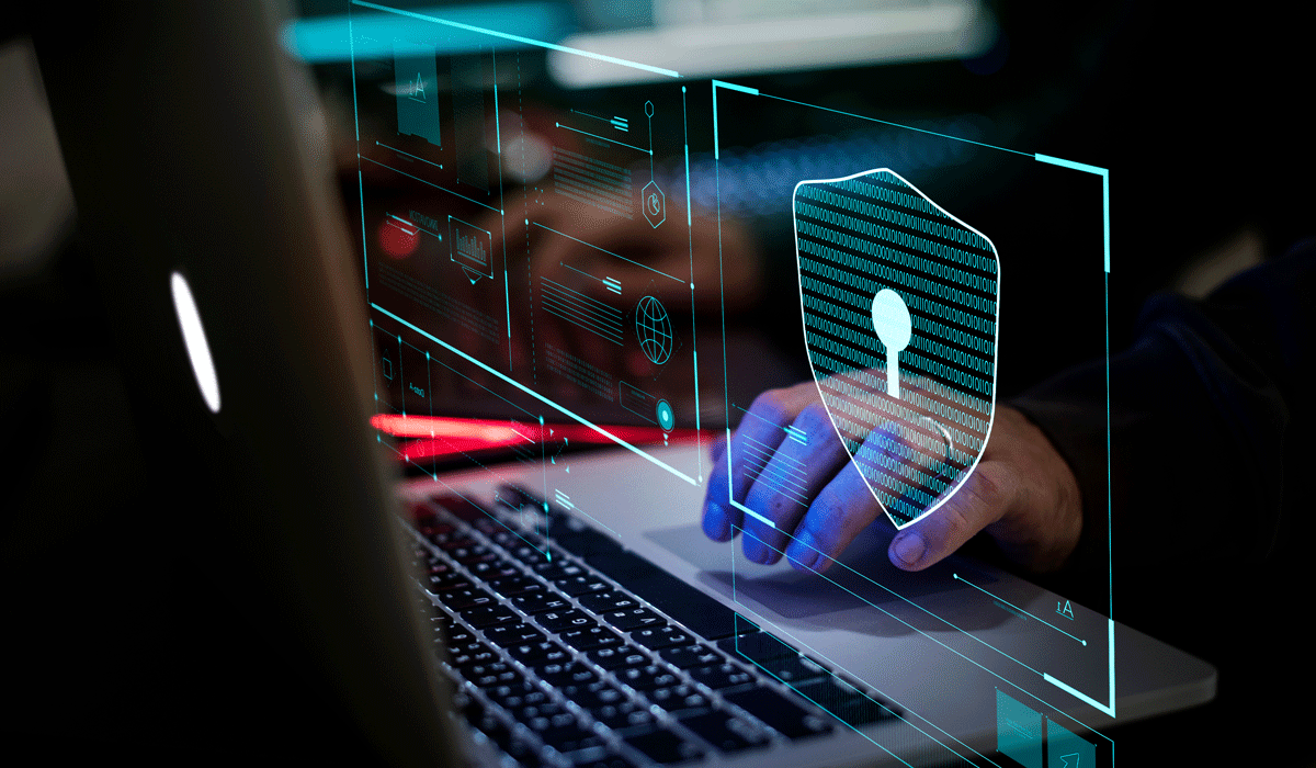 a person using a laptop with a shield on the screen