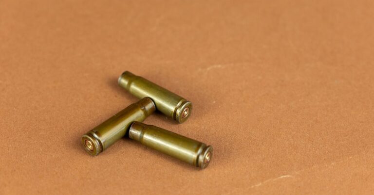 a group of three brass bullet heads on a brown surface