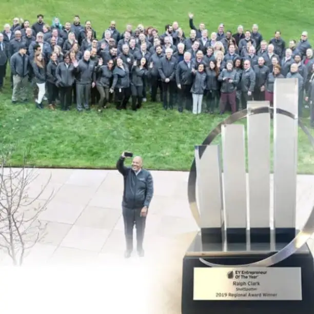 a group of people standing next to a trophy