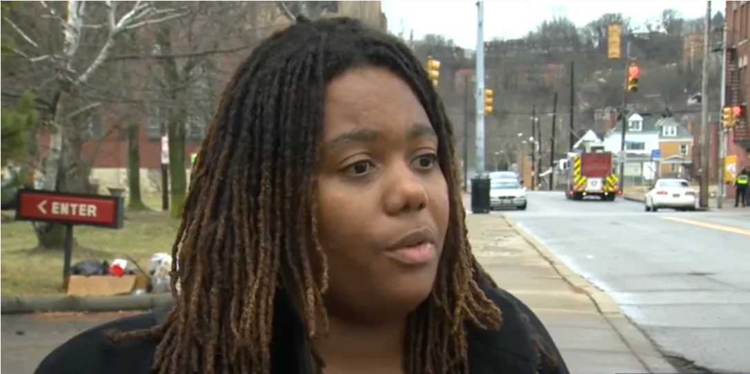 a woman with dreadlocks standing on a street corner