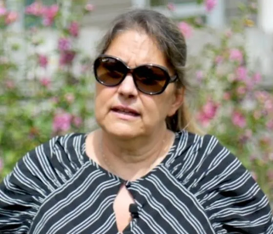 a woman in a black and white shirt and sunglasses