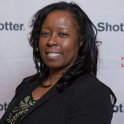 a woman standing in front of a white backdrop