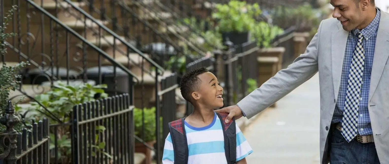 a man holding the hand of a young boy