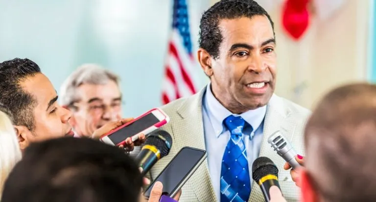 a man in a suit speaking to a group of people