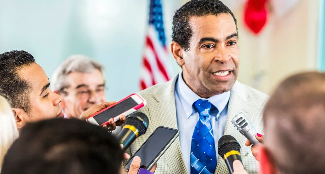 a man in a suit speaking to a group of people