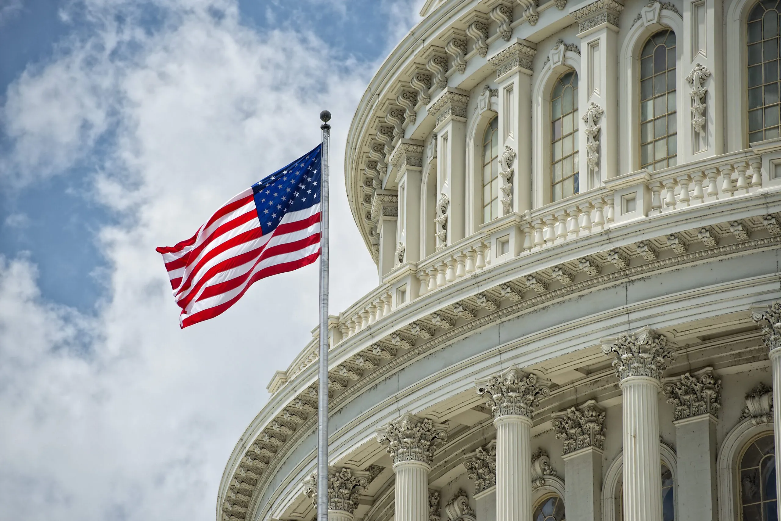 an american flag flying in front of the capitol building