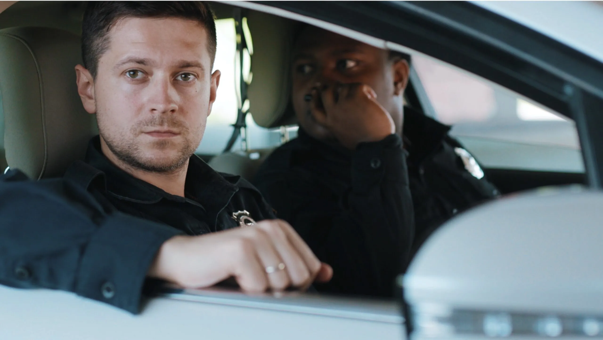 a man sitting in a car talking on a cell phone