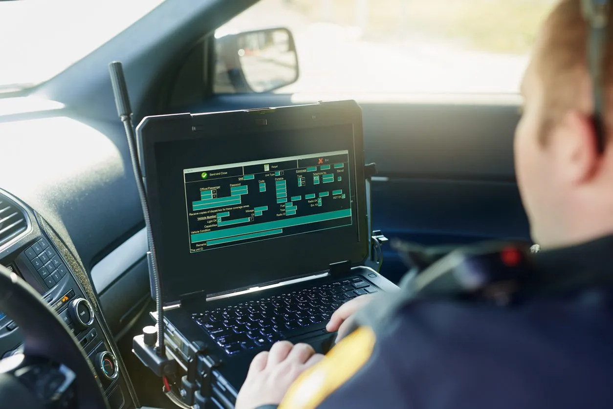 a man sitting in a car using a laptop computer