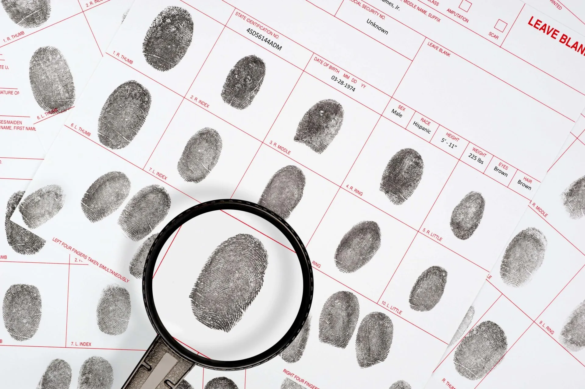 A forensic inspector looks at a suspect fingerprint on legal detective files.