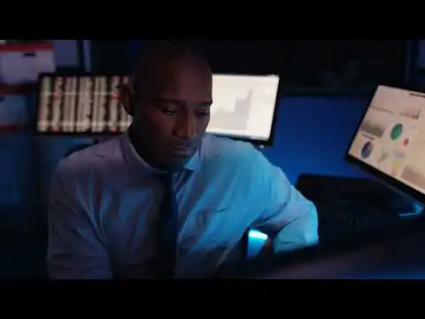 a man sitting in front of a computer monitor