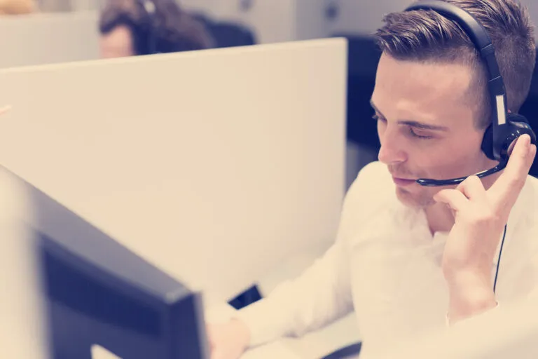 a man wearing a headset and using a computer