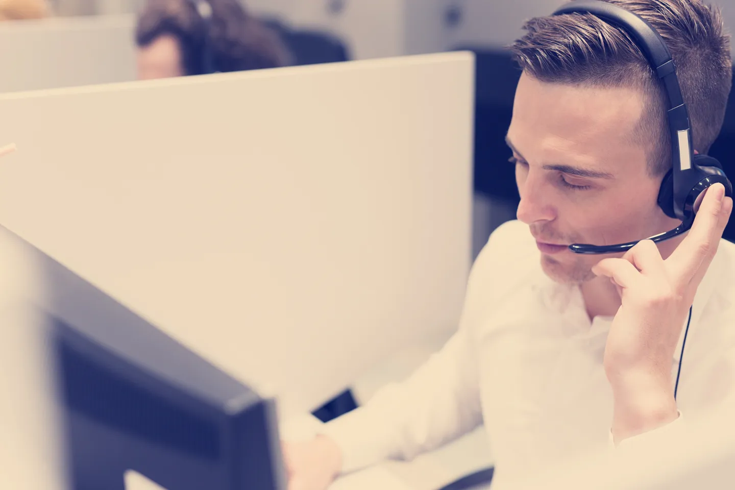 young smiling male call centre operator doing his job with a headset