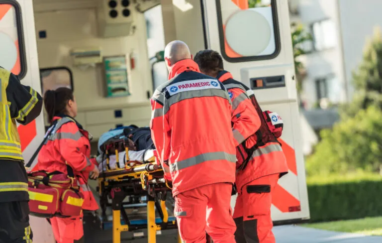 a group of emergency personnel loading a person on a stretcher