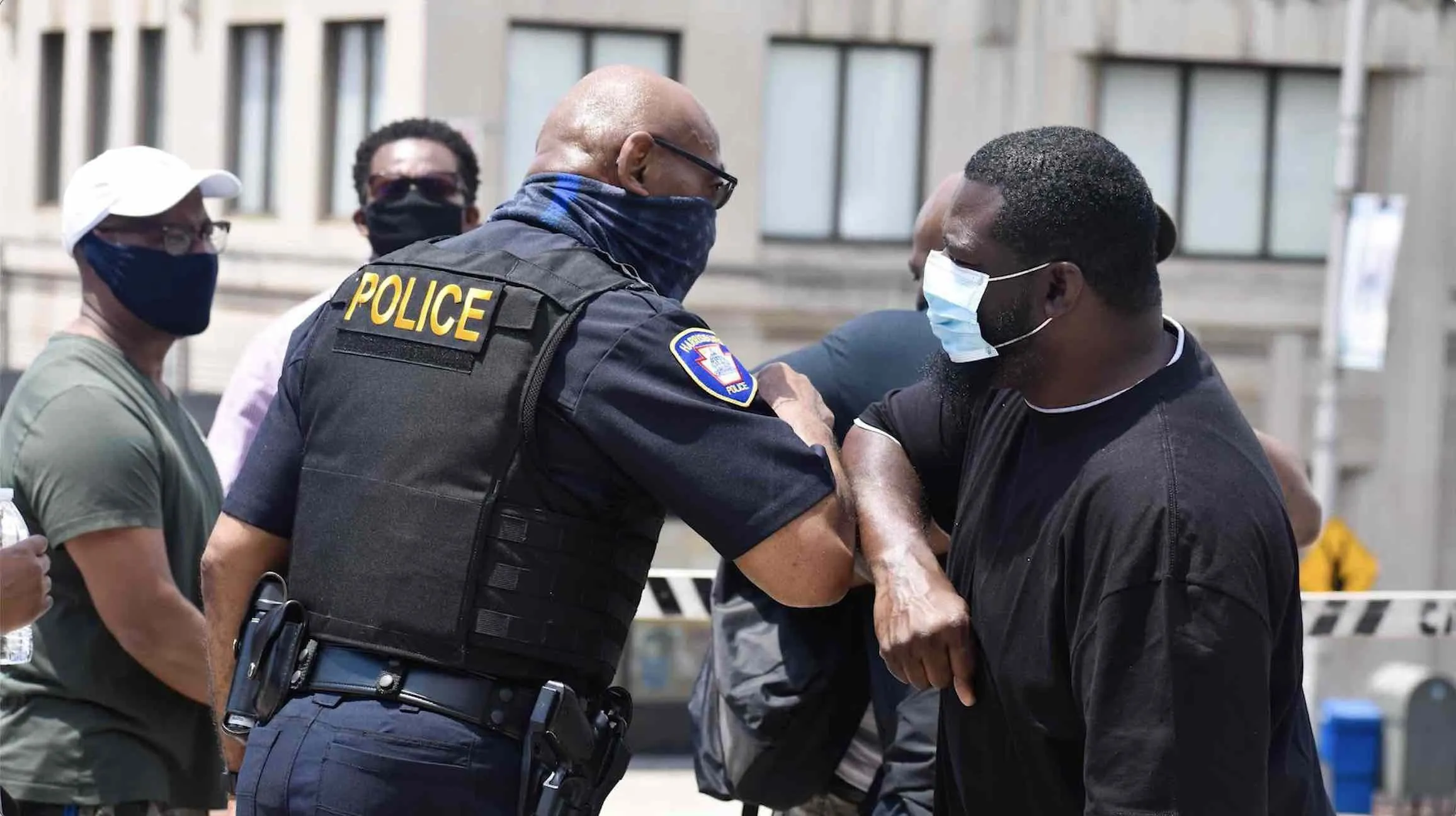 a police officer wearing a face mask talking to a man