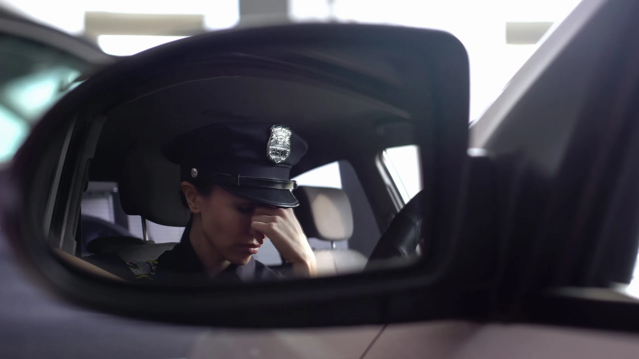 a police officer sitting in a car talking on a cell phone