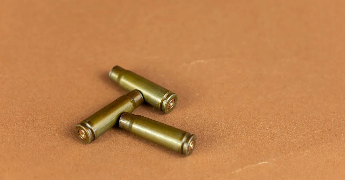 a group of three brass bullet heads on a brown surface