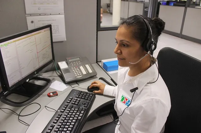 a woman wearing a headset sitting in front of a computer