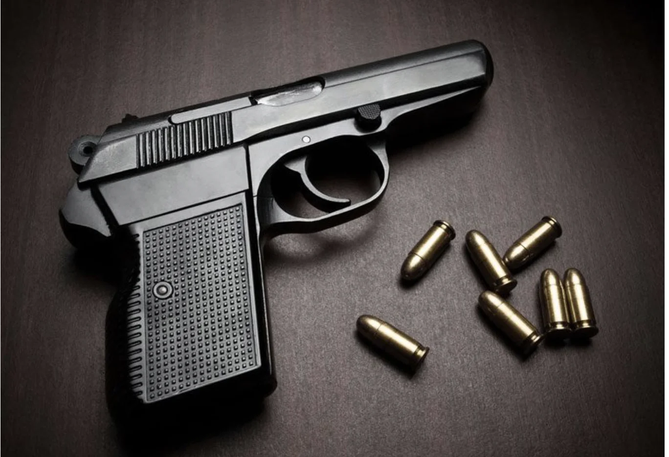 a gun and some bullet shells on a table