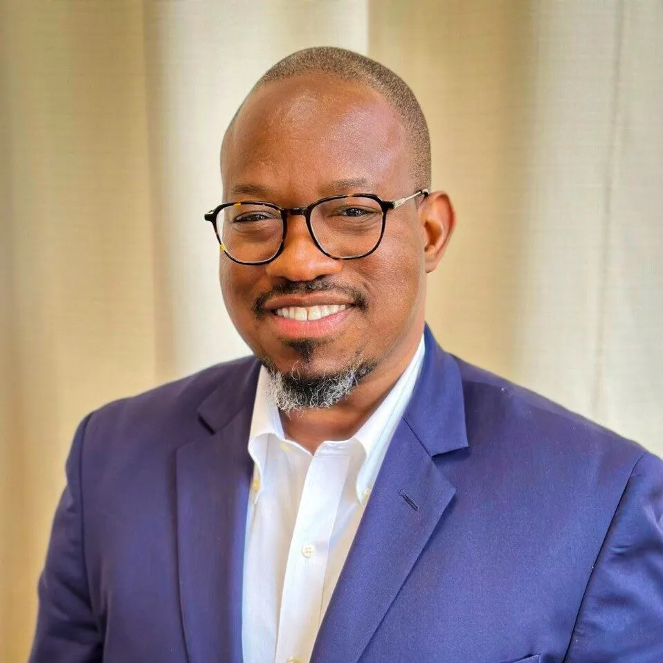 a man in a purple suit and glasses