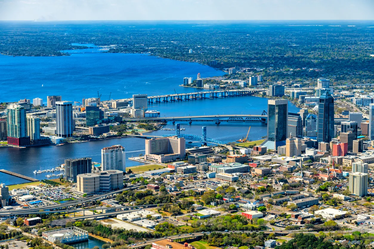 an aerial view of a city with a bridge in the background