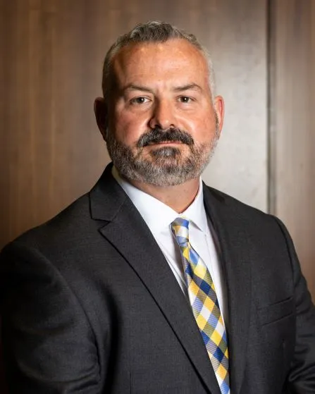 Headshot image of a man in a suit and tie, Josh Judah.