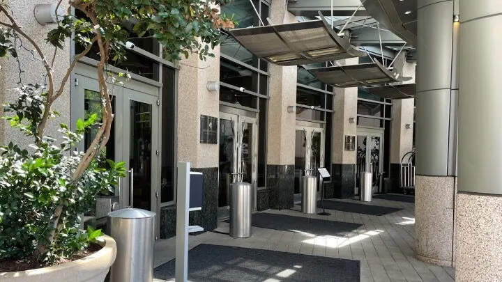 Image of building entrance with discreet weapons detection silver SafePointe bollards creating entrance lanes.