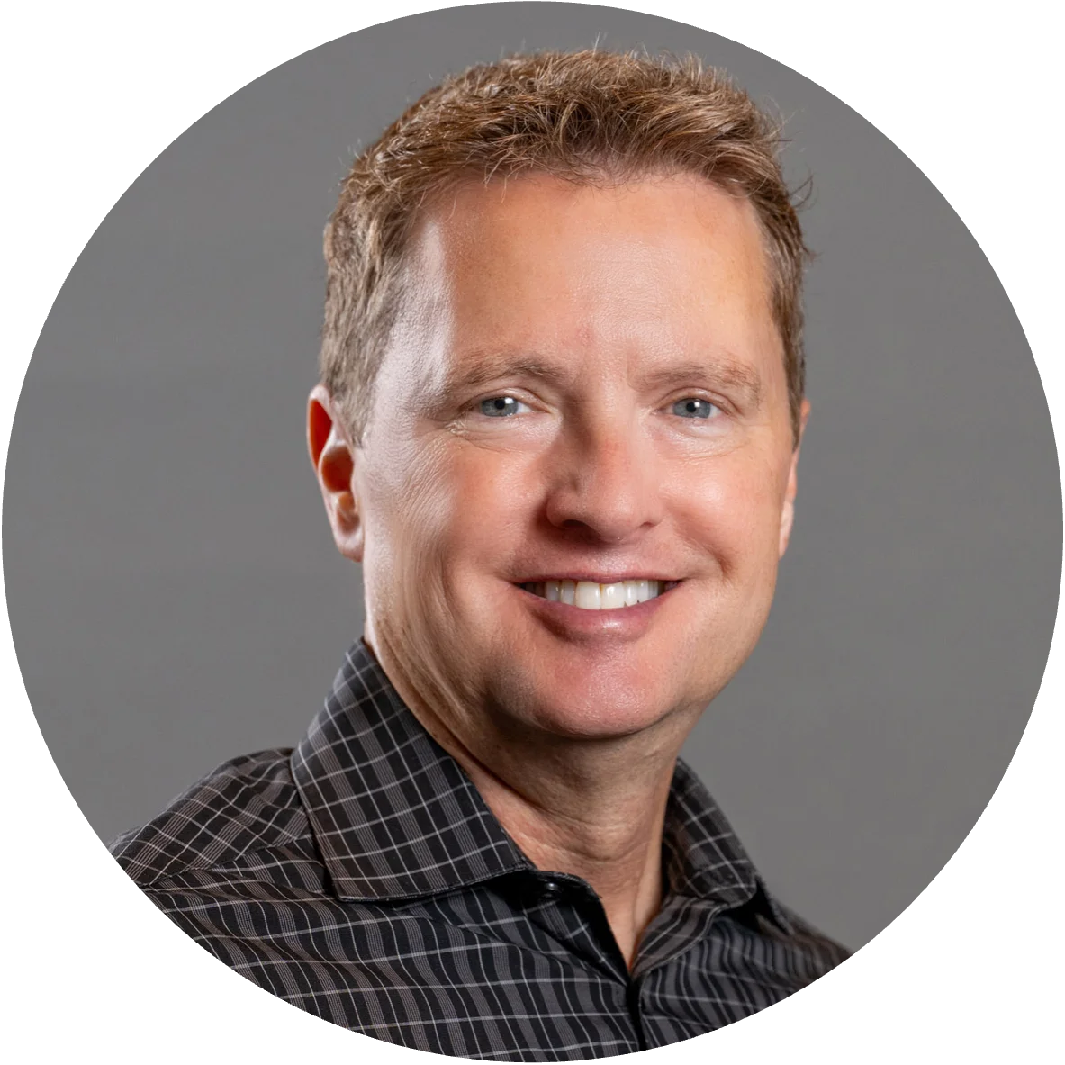 Man's face in circular image, smiling for a headshot photo.